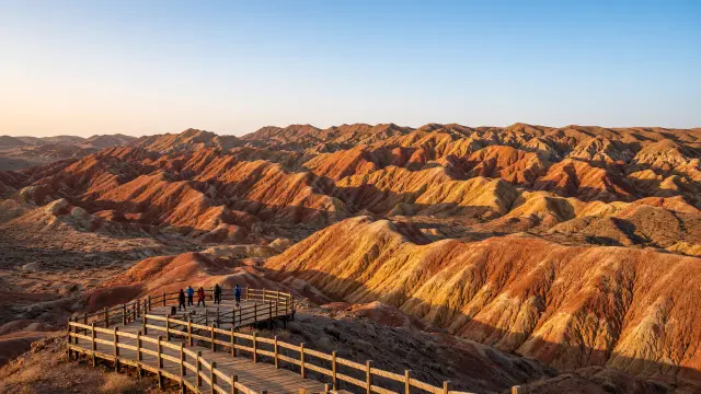 Reizigers op een uitkijkplatform bij de gestreepte Danxia-bergen van Zhangye