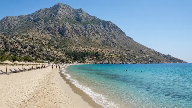 Lang zandstrand met turquoise water bij Kampos in het zuidwesten van Samos, met de berg Kerkis erachter