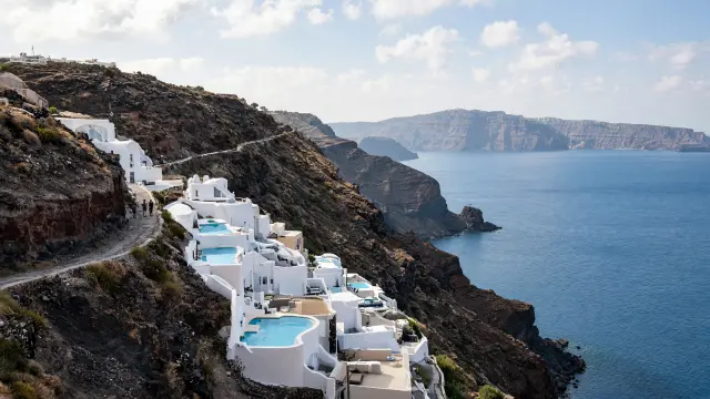 Witte hotels met kleine zwembaden op de kliffen van de caldera bij Imerovigli op Santorini