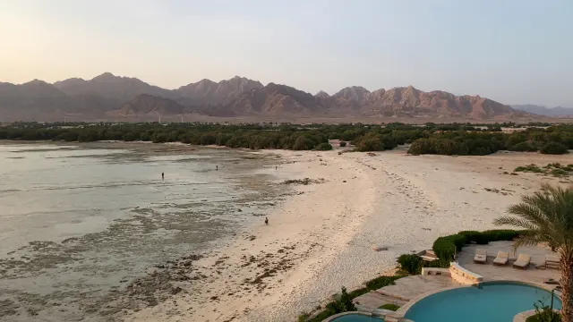 Breed licht strand met een ondiep rif en de bergen van de Sinaï bij Nabq Bay