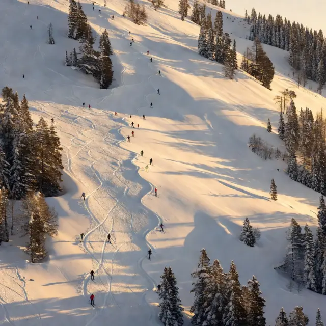 Bergstation met moderne gondel in alpendorp met sneeuw bedekte hellingen en skiërs op brede pistes in winters landschap