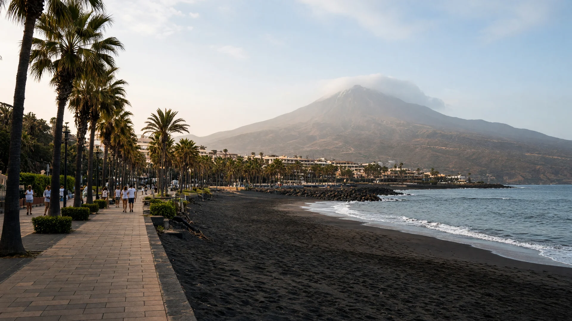 Strand en promenade met palmbomen op Tenerife, met de Teide op de achtergrond