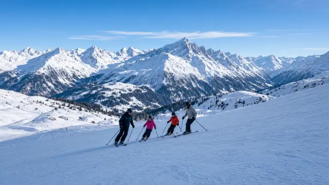 Gezin met kinderen op een brede blauwe piste in het Stubaital