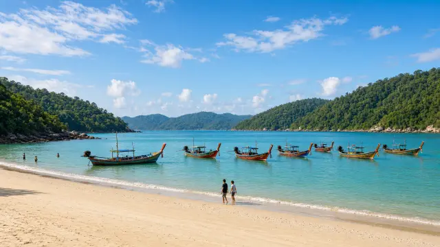 Zandstrand met houten longtailboten in de turquoise Andamanzee op Phuket
