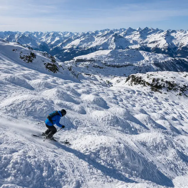 Panorama van Verbier met luxe chalets, drukke après-ski terrassen en imposante bergtoppen op de achtergrond in de winter