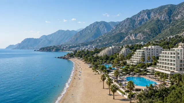 Resorts met zwembaden aan een zandstrand ten westen van Alanya met het Taurusgebergte erachter