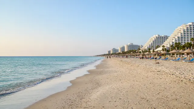 Lang zandstrand met grote resorts en ligbedden in Lara bij Antalya