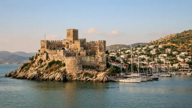 Het kasteel van Sint-Pieter aan de haven van Bodrum met witte huizen op de heuvels