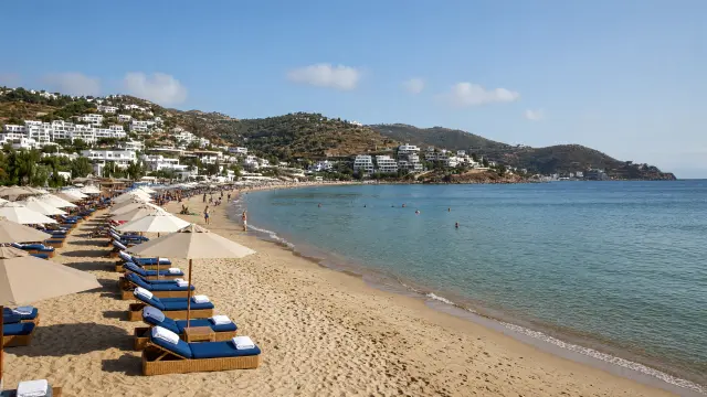 Gebogen zandstrand met ligbedden in de baai van Gümbet bij Bodrum