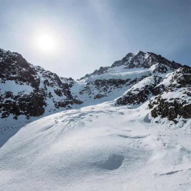 Appartementen en chalets aan het meer van Tignes Le Lac met de besneeuwde Grande Motte op de achtergrond
