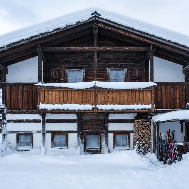 Gezellig Tiroler houten chalet met sneeuw op het dak in Westendorf, met bergen op de achtergrond