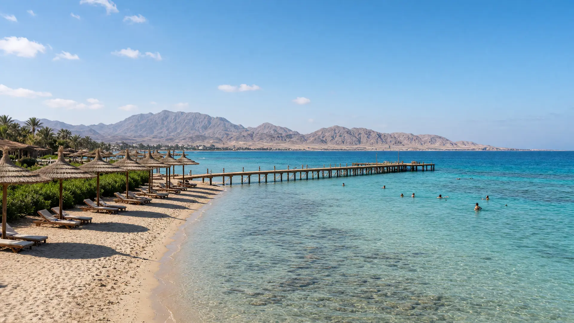Strand met parasols en een houten steiger aan de Rode Zee bij Hurghada