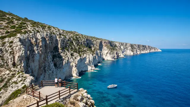 Witte kalkstenen kliffen boven een turquoise baai aan de westkust van Zakynthos, gezien vanaf een uitkijkplatform