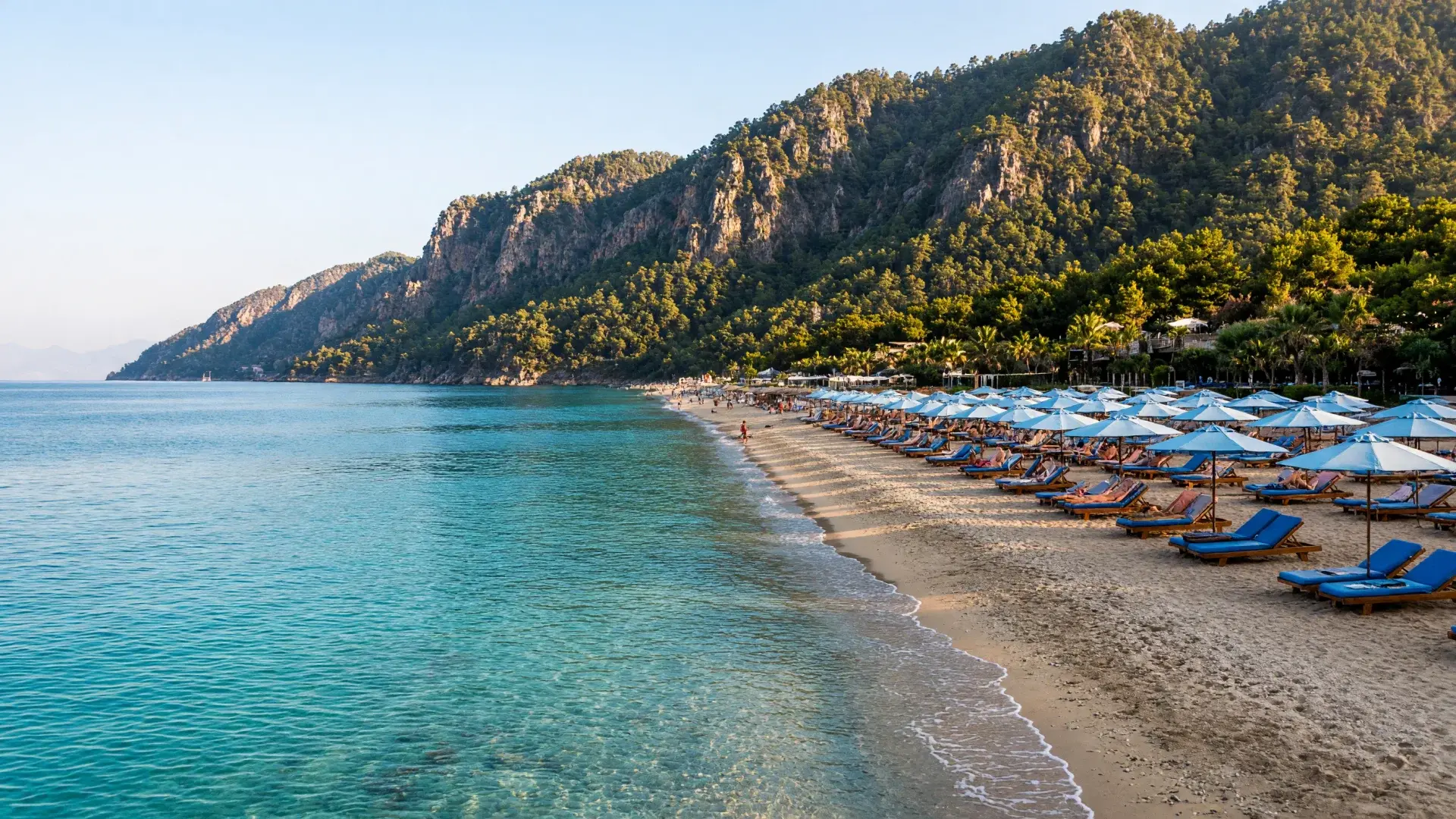Strand met turquoise zee en beboste bergen aan de Turkse Riviera bij Antalya
