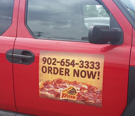 Pizza delivery magnet on a red SUV.