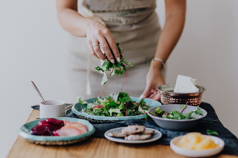 Femme dressant des plats : une alimentation équilibrée booste la fertilité féminine.