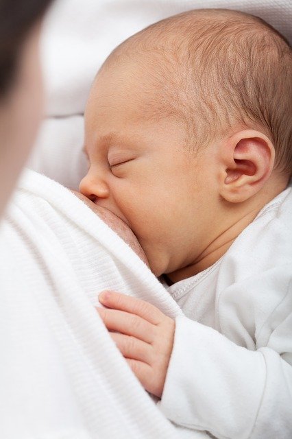 Bébé en train de téter : définition, bienfait et dosage du colostrum.