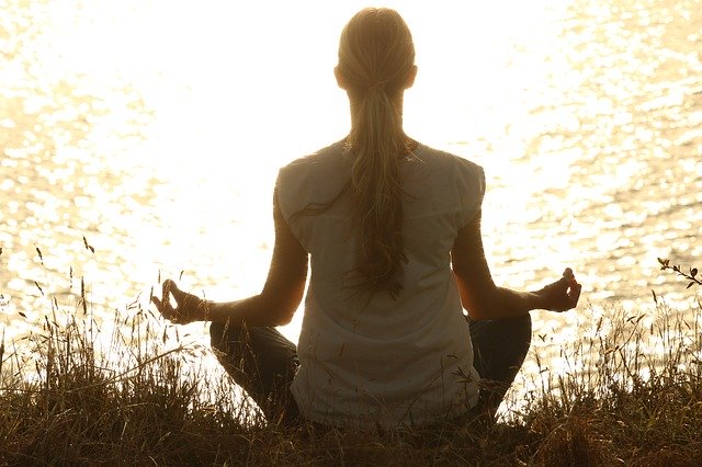 Femme en train de pratiquer la méditation de pleine conscience : définition et grands principes.