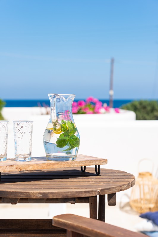 Domus Litus Superior Studio μπαλκόνι με θέα θάλασσα και μικρό τραπέζι με λεμονάδα πάνω του.