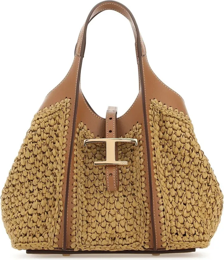 Handbag realized in raffia with leather inserts enriched by metal T detail at the front.