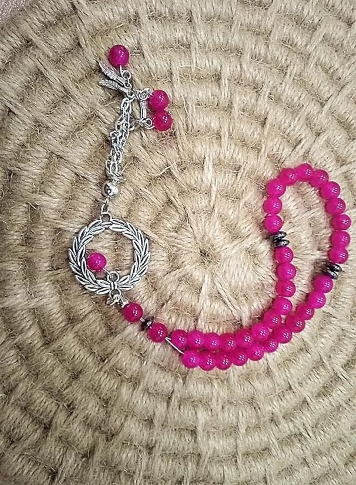 pink rosary of 33 beads with a silver pendant