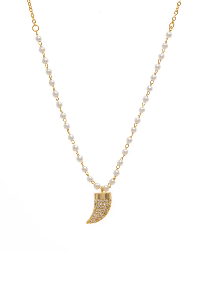 A pearl necklace with a fang pendant decorated with crystals