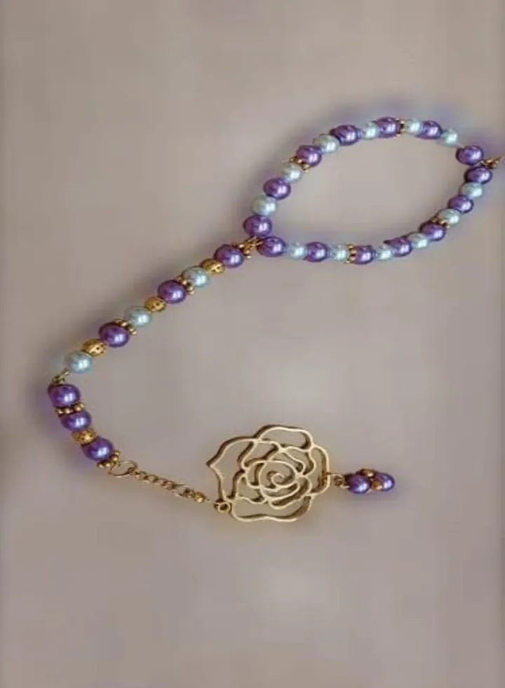 Car mirror hanger of white and violet beads with a pendant in the shape of a flower