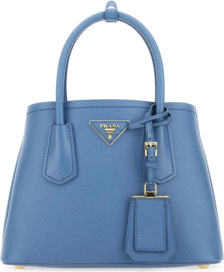 Handbag realized in Saffiano leather enriched by iconic logoed triangle at the front and detachable tonal leather accessory.