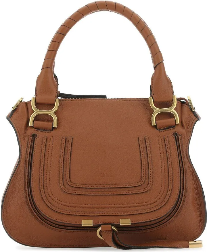Handbag realized in pebble calf leather characterized by embossed logo on the flap enriched by tonal leather patches at the front.