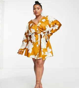 ASOS DESIGN Curve satin batwing mini dress with button front detail and tie front in mustard floral print