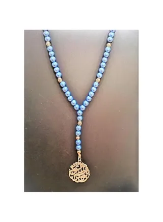 The car rear view mirror pendant is blue and gold beads with a religious gold pendant 