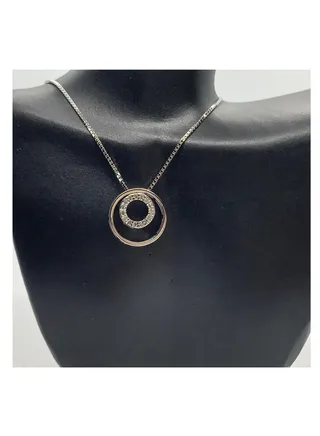 A pendant necklace made of silver with a unique circular shape 