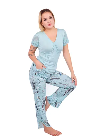 A two-piece pajama set for women with side slits in a floral print and a blouse with half sleeves embroidered with soft lace and a buttoned collar for more elegance and beauty from Daadouch. 