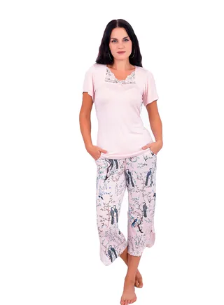 A Bermuda pajama set with side slits and short pants with a floral and bird print, in addition to a plain blouse with a lace-embroidered collar for more elegance and beauty from Daadouch. 