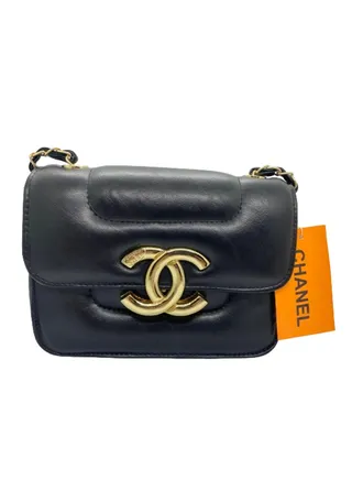 A luxurious black women's handbag with a gold metal handle from Chanel 