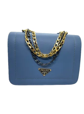 A luxurious women's leather bag with a gold and black metal handle and light navy blue color 
