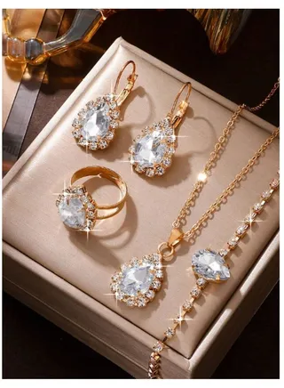 Elegant and distinctive women accessories set consisting of chain with pendant design studded with shiny crystals along with earrings bracelet and ring 