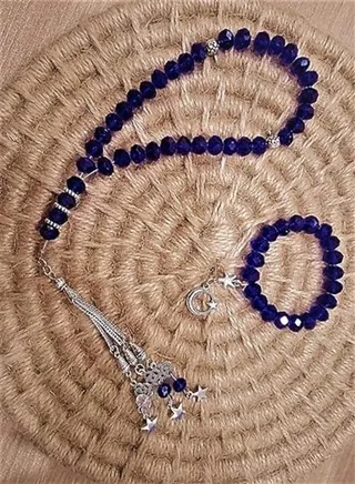 A rosary set of 33 beads and a bracelet, blue, of shiny beads, with a silver pendant, ending with stars 