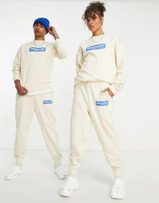 ASOS Daysocial unisex relaxed sweatpants with blue badge logo print in ecru - part of a set