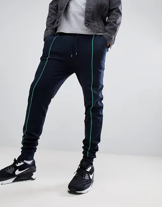 ASOS DESIGN skinny sweatpants in navy with light green piping