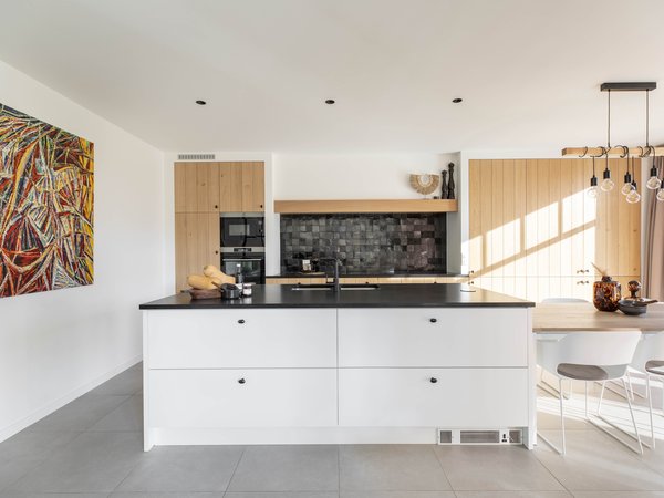 Keuken met natuurhout, wit laminaat en zwarte natuursteen