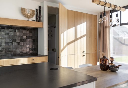 Keuken met natuurhout, wit laminaat en zwarte natuursteen