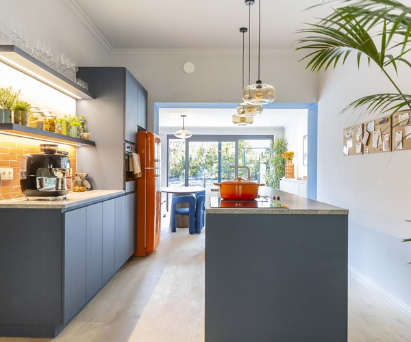 Cuisine colorée avec stratifié Bleu Baltique, frigo orange et plan de travail en pierre naturelle