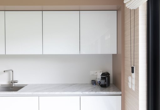 Moderne keuken met witgelakte glanzende kastdeuren