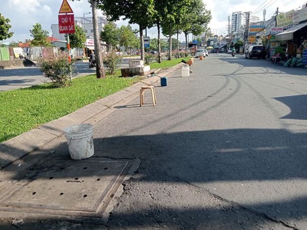 In Vietnam, residents place buckets, basins, concrete blocks on roadbed to claim spaces for trade