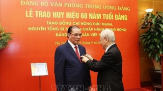 60-year Party membership badge presented to former Party chief Nong Duc Manh