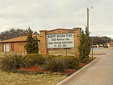 Gates and outdoor sign with text Robert Degan Place, 3402 Rebecca Lane, Equal Housing Opportunity, Tx. 327-003.