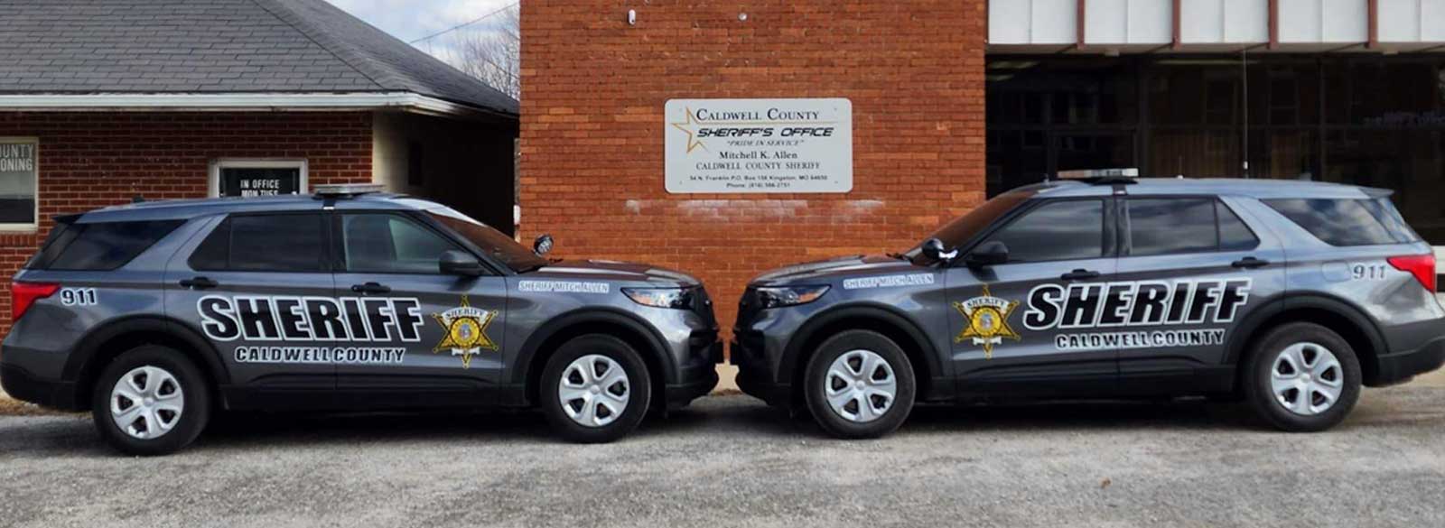 Two CCSD patrol vehicles facing each other in front of the Sheriff's Office