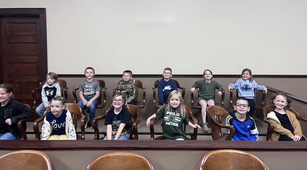 Twelve students sitting in chairs.