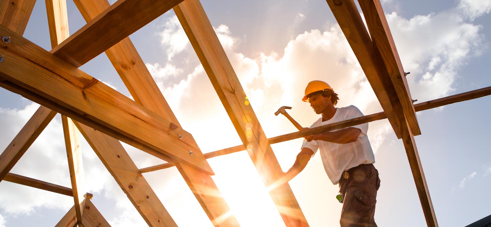 Man framing house with sun glare in background